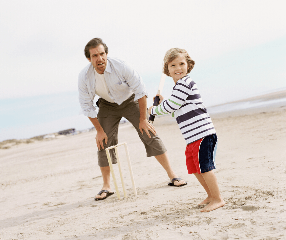 Father and Son playing beach cricket